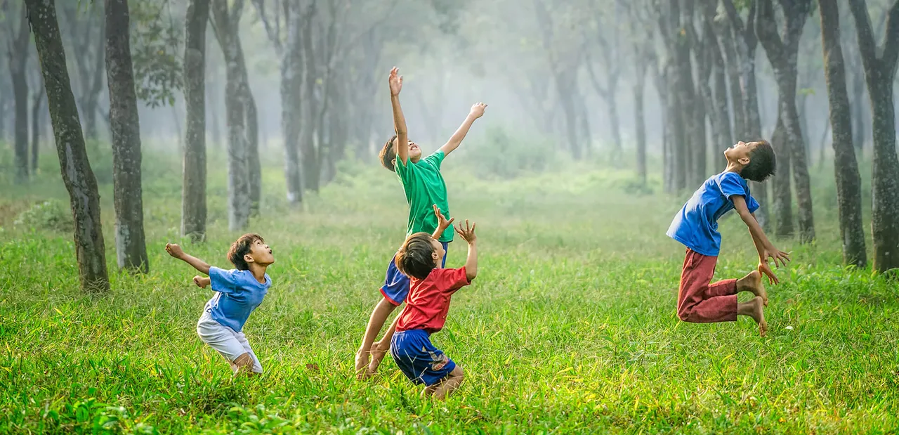 Children playing outdoors in a green field